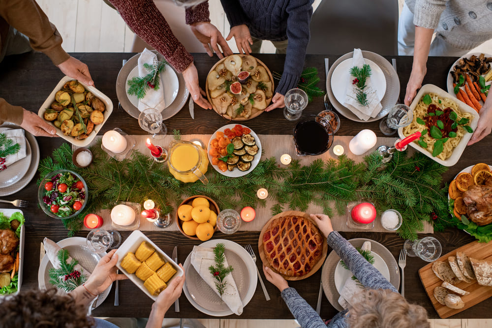 mesa de cena de navidad con las manos de la familia